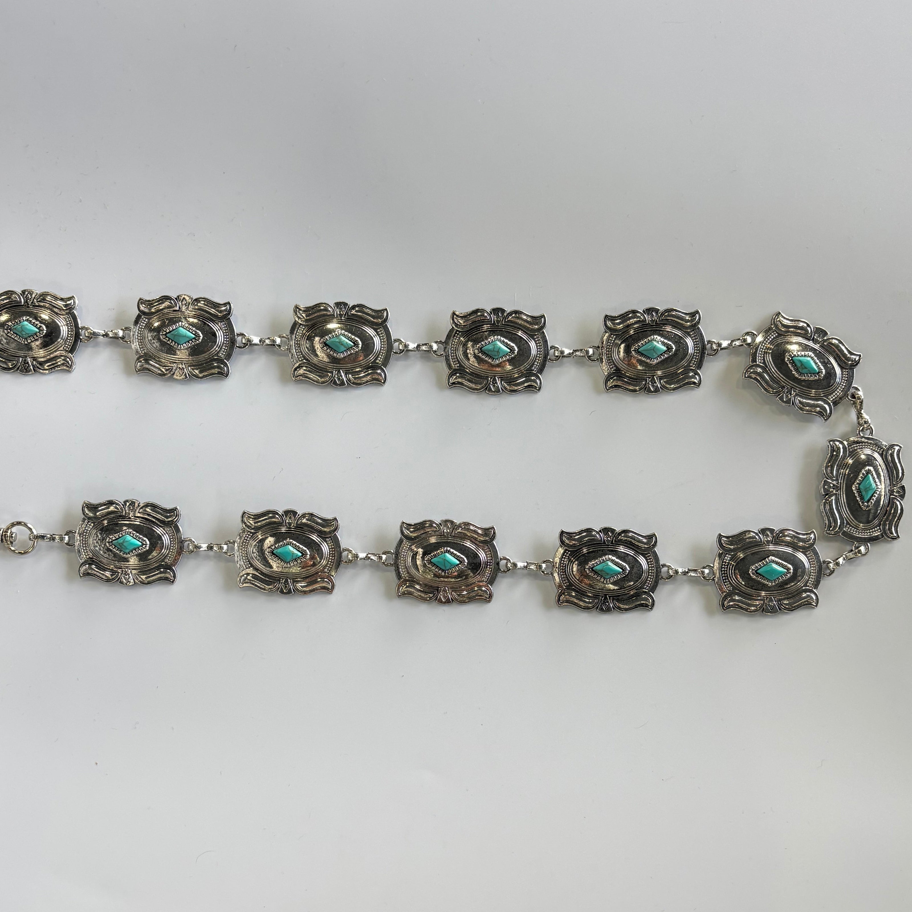 Cinturón metálico plateado con rombo turquesa