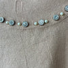 Top cuello alto con aplicaciones