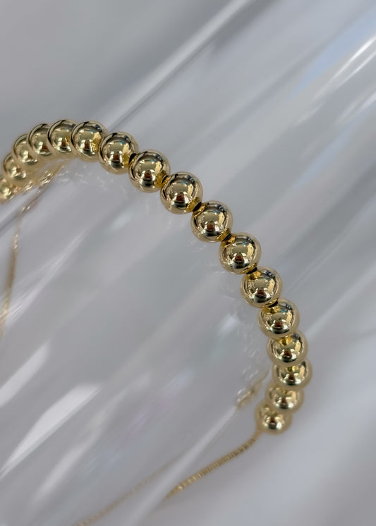 Pulsera ajustable con balines dorados